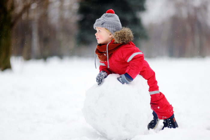 23416016 Little Boy In Red Winter Clothes Having Fun With Snowman